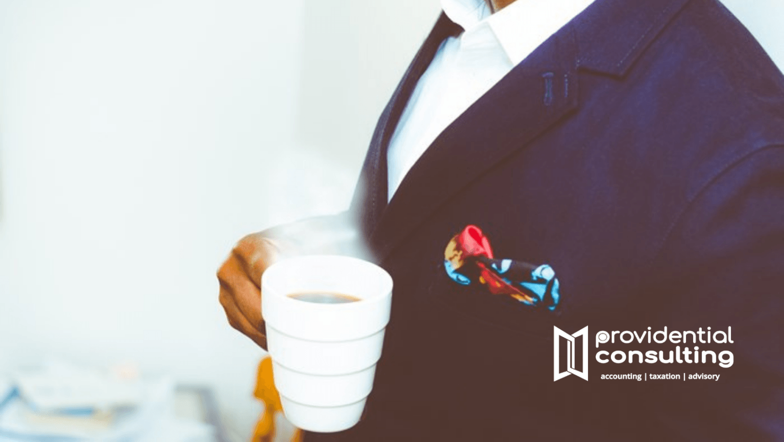 Providential Consulting advisor in a navy suit holding a coffee cup