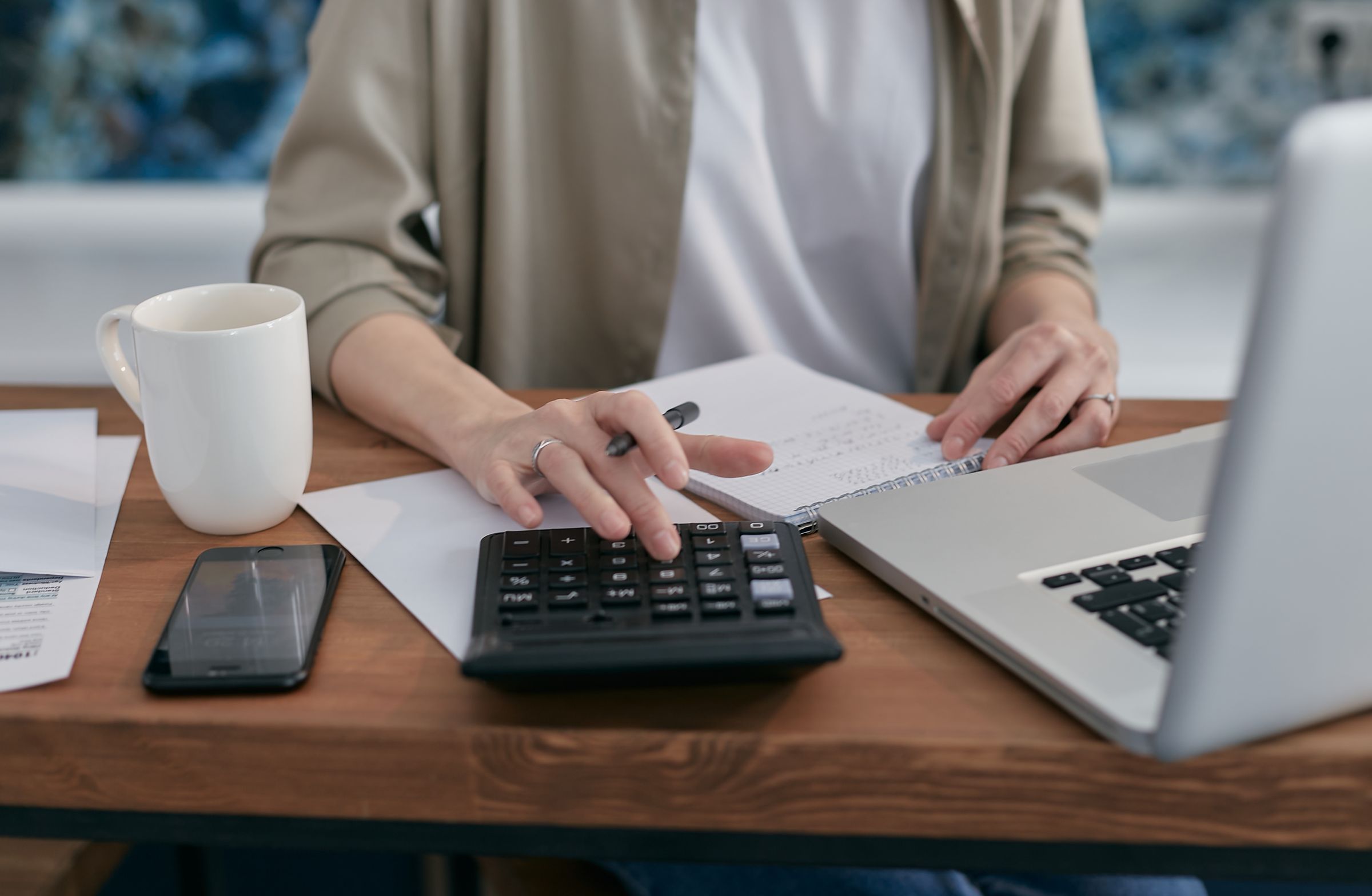 Professional desk with calculator, laptop and tax documents