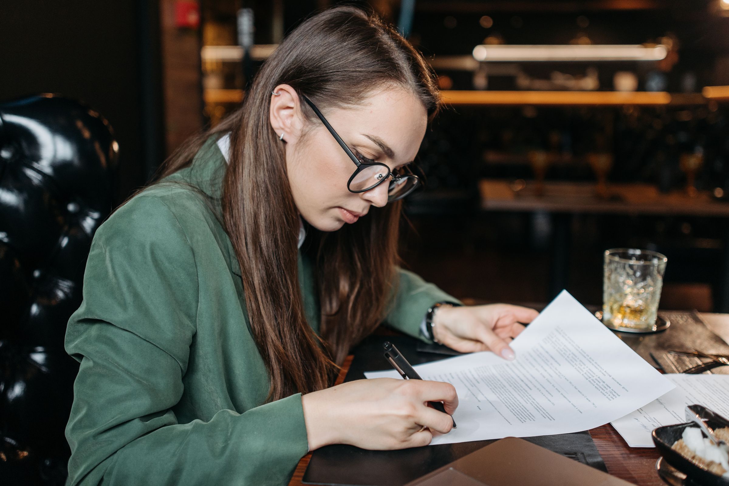 Professional reviewing and signing documents at a desk