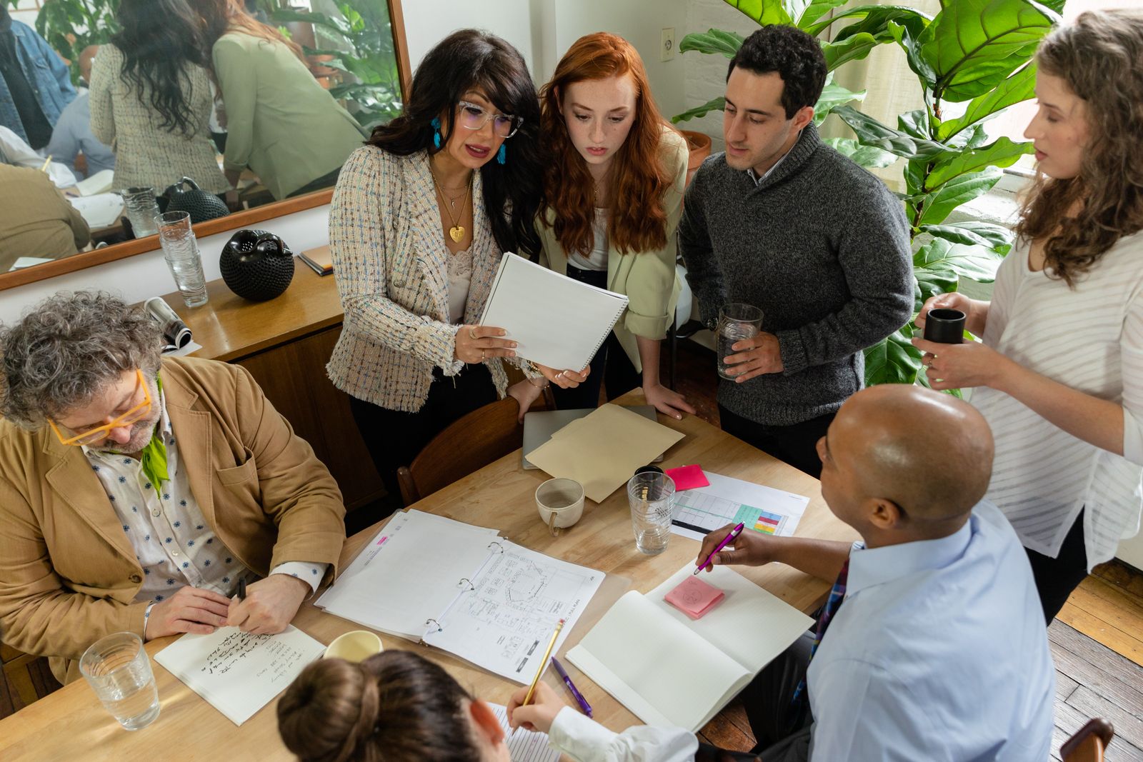 Team of colleagues collaborating around a table with notebooks