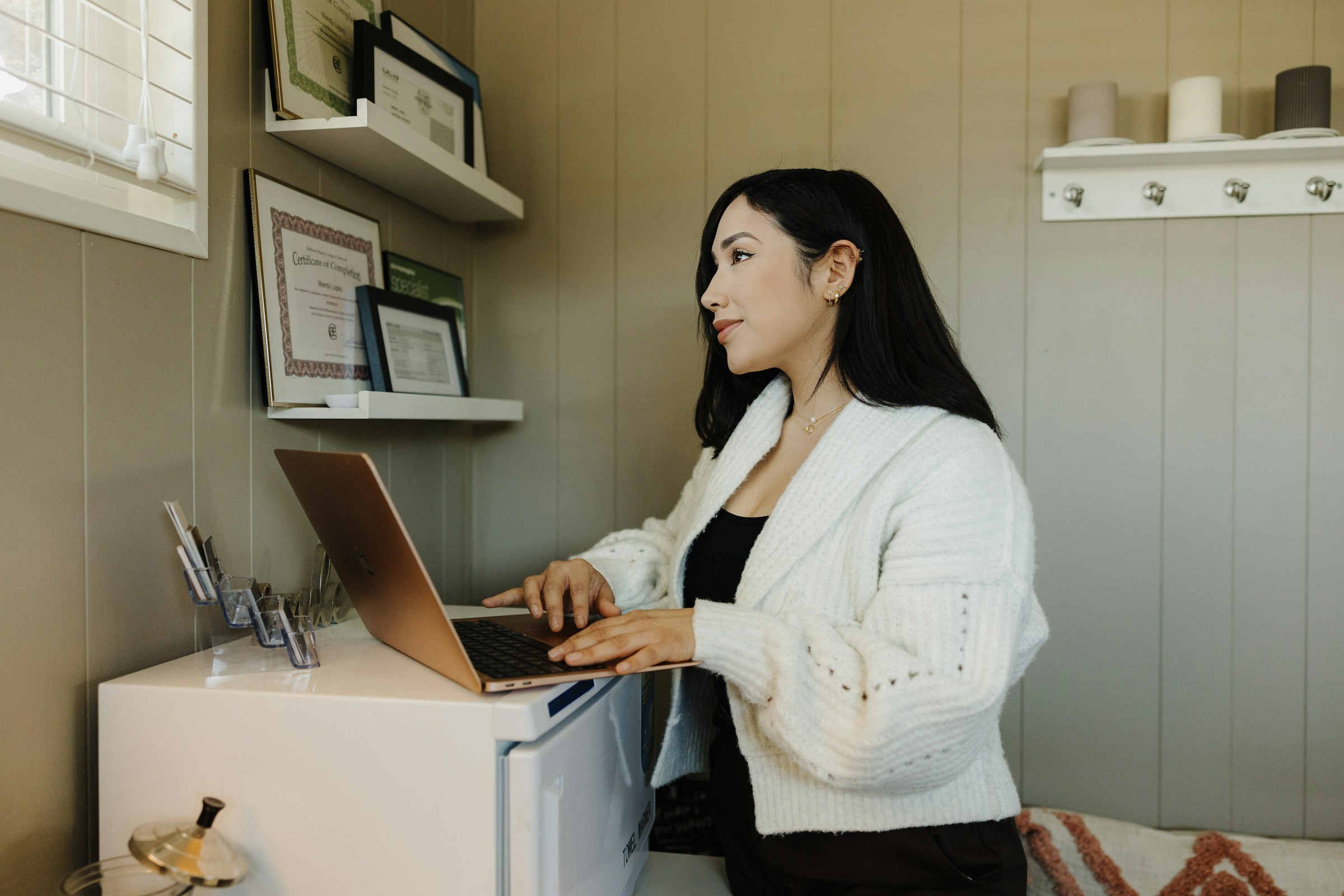 Small business owner working on a laptop at a home office desk